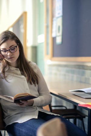 woman-in-white-long-sleeve-shirt-sitting-on-chair-while-3776190